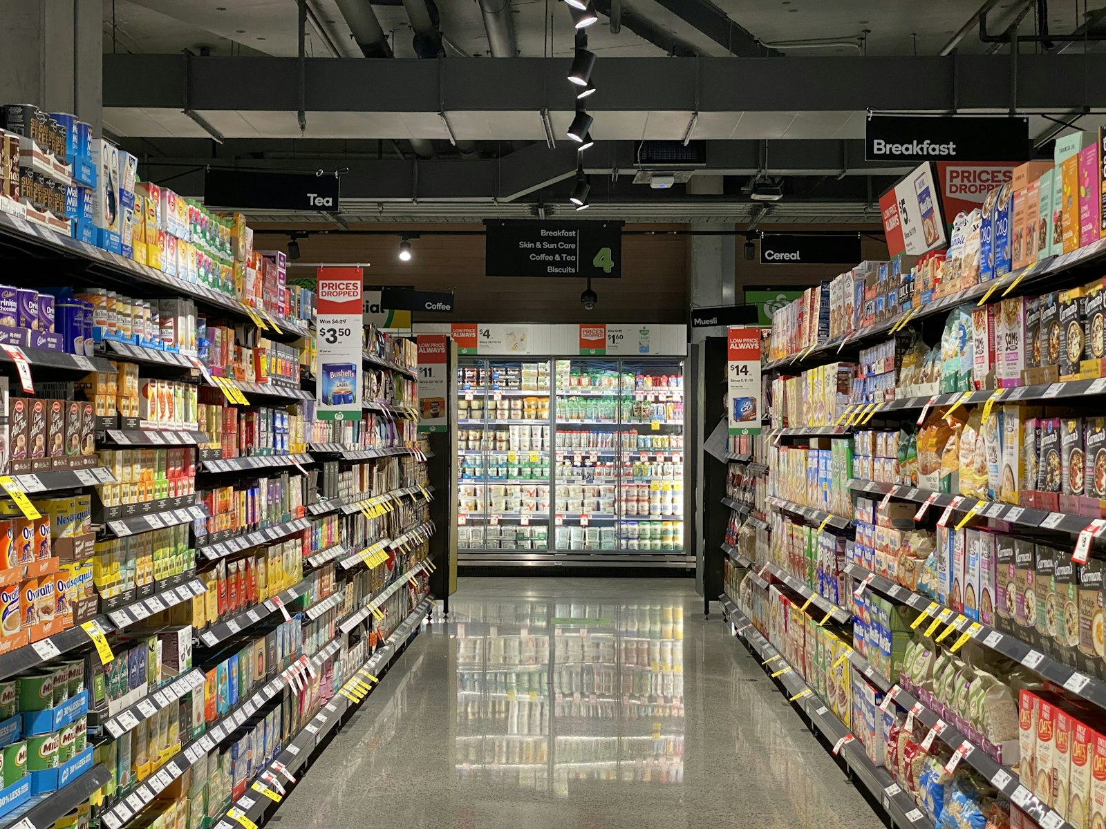 Bright supermarket aisle with packed product shelves